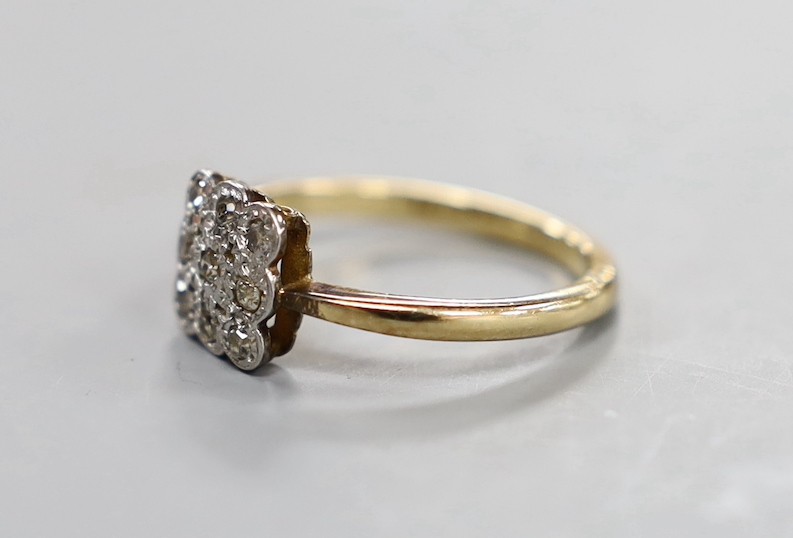 A 1920's 18ct and nine stone diamond cluster set tablet ring, size R, gross weight 4 grams.